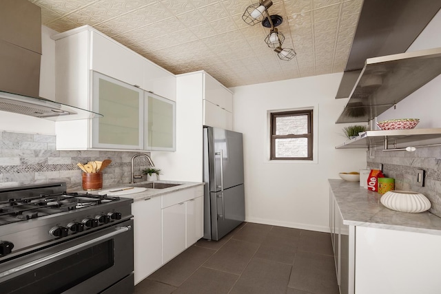 kitchen featuring a sink, white cabinets, appliances with stainless steel finishes, wall chimney range hood, and open shelves