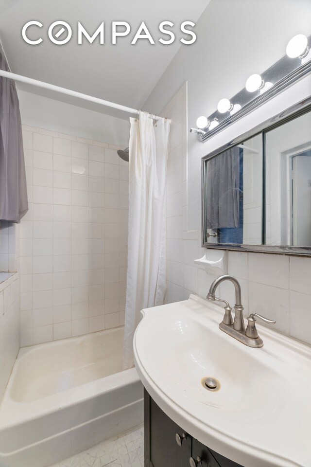 bathroom with tasteful backsplash, vanity, and shower / bathtub combination with curtain