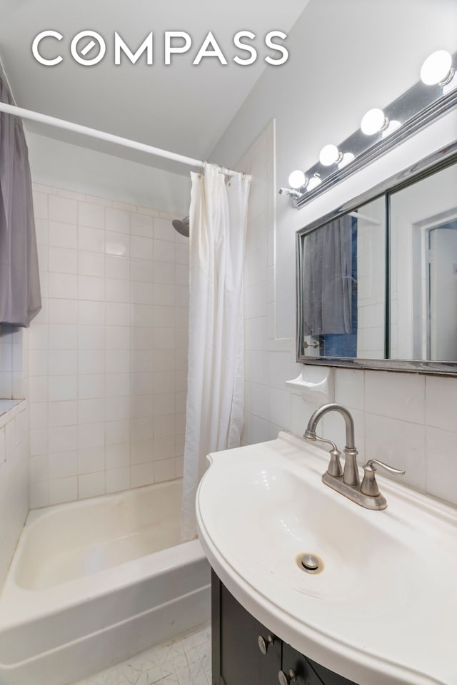 full bath with decorative backsplash, tile walls, shower / bath combination with curtain, and a sink