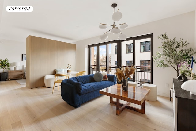 living room with an inviting chandelier, light wood-style floors, and visible vents