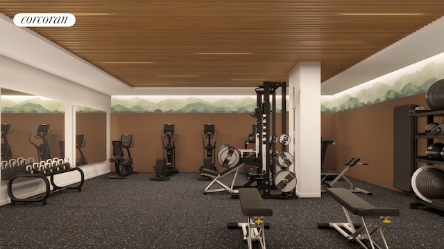 exercise room with a raised ceiling, wood ceiling, and visible vents