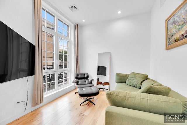 living room with wood-type flooring, visible vents, and recessed lighting