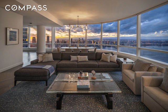 sunroom featuring a water view, a view of city, and a chandelier