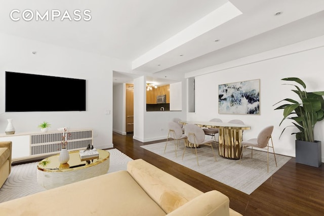 living room with baseboards and dark wood-type flooring