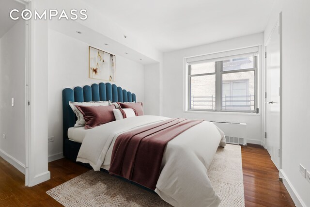 bedroom featuring radiator and dark hardwood / wood-style floors