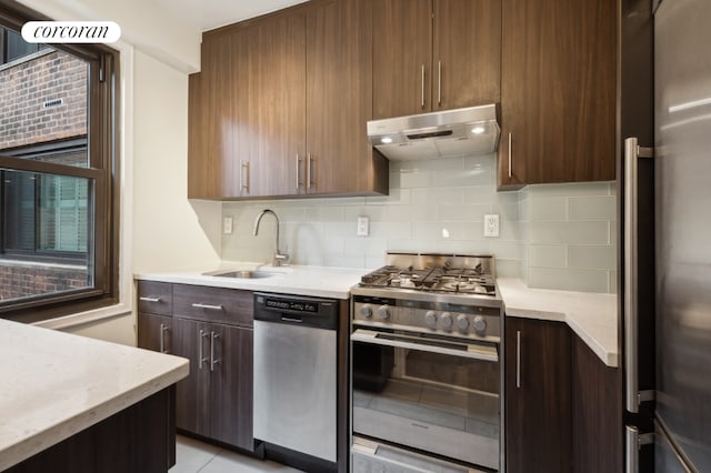 kitchen with tasteful backsplash, appliances with stainless steel finishes, sink, and light tile patterned floors