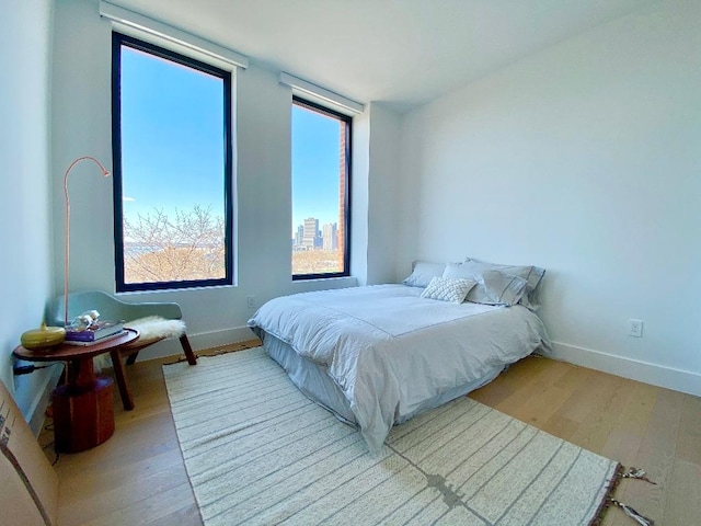 bedroom with light wood-type flooring and baseboards