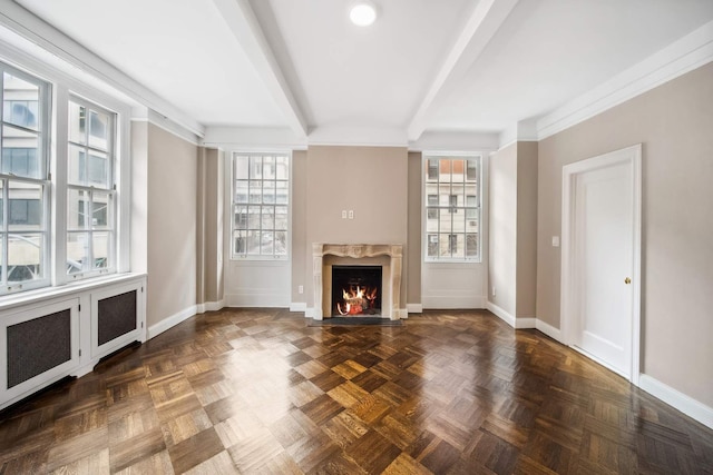 unfurnished living room with beam ceiling, baseboards, and a high end fireplace