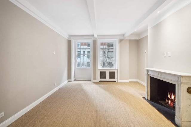 unfurnished living room featuring beamed ceiling, carpet flooring, baseboards, and a high end fireplace