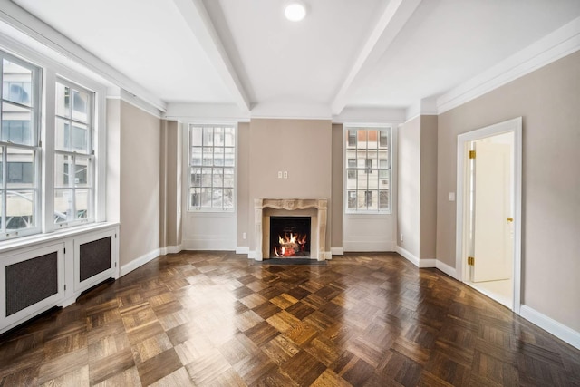 unfurnished living room with beam ceiling, baseboards, and a premium fireplace