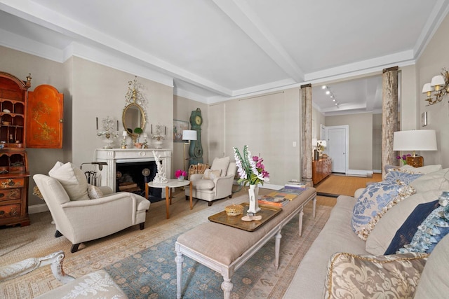 living area featuring beam ceiling, wood finished floors, a fireplace, and baseboards