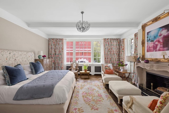 bedroom with beam ceiling, a fireplace, and an inviting chandelier