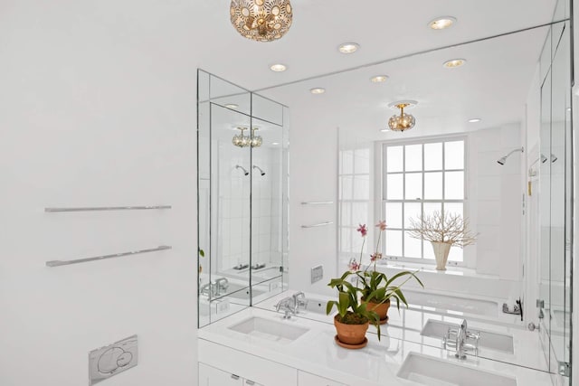 bathroom featuring a sink, a shower with shower door, recessed lighting, and double vanity