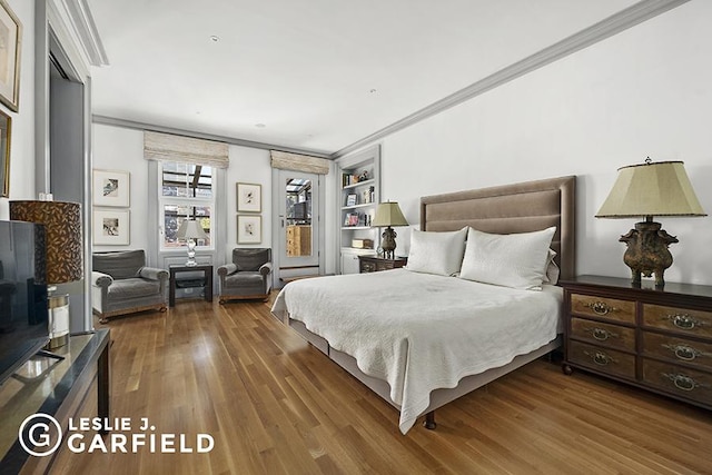 bedroom with ornamental molding and hardwood / wood-style flooring