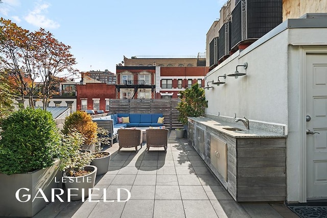 view of patio with an outdoor living space and sink