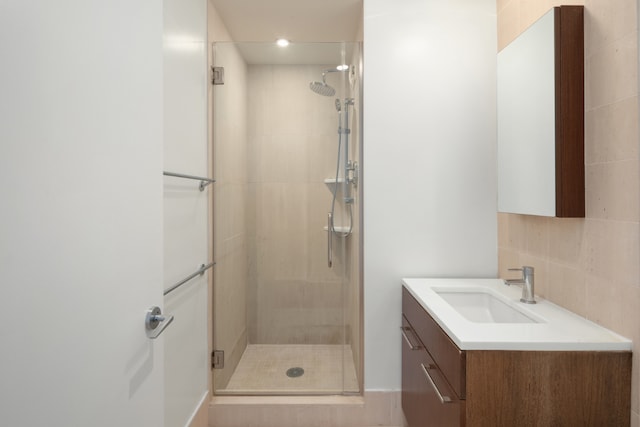 bathroom featuring walk in shower, vanity, and decorative backsplash