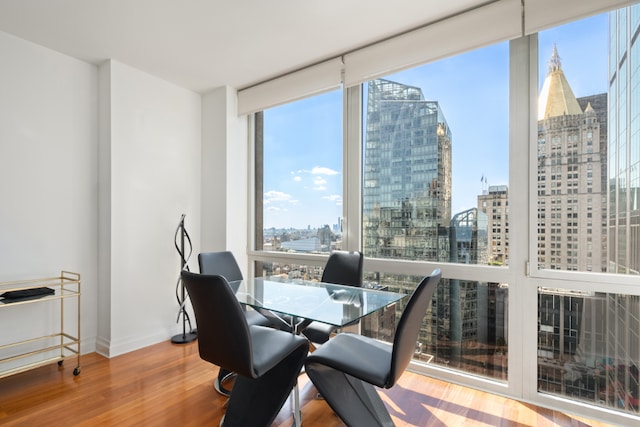 dining area with a wall of windows and hardwood / wood-style floors