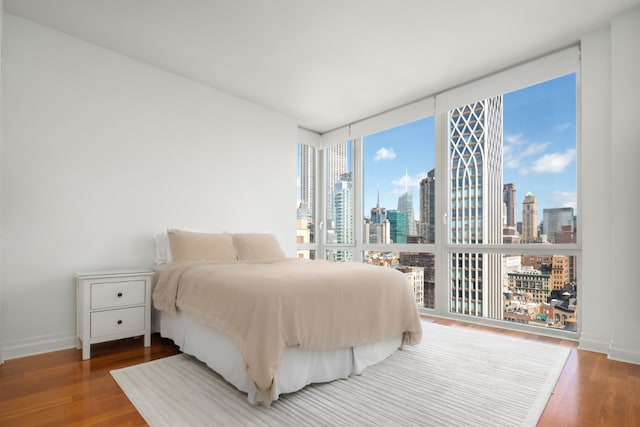 bedroom with hardwood / wood-style flooring and expansive windows