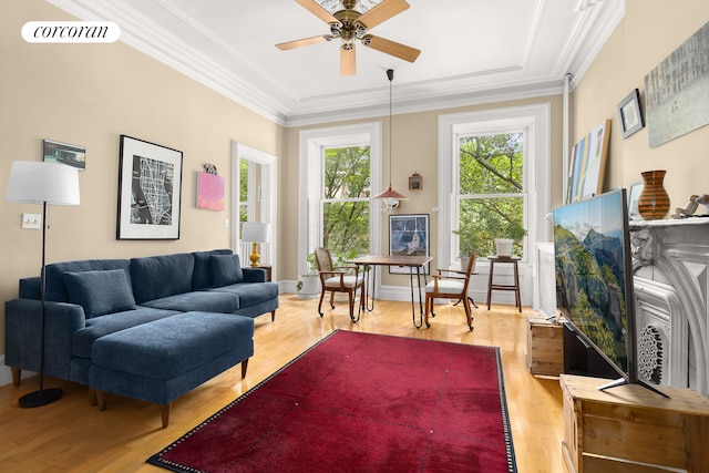 living room with baseboards, visible vents, ceiling fan, wood finished floors, and crown molding