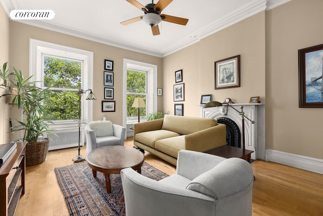 living area featuring crown molding, a fireplace, visible vents, light wood-style flooring, and baseboards