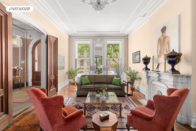 living area featuring visible vents, crown molding, baseboards, and wood finished floors