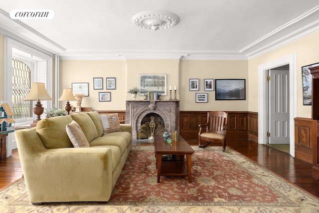 living area featuring hardwood / wood-style flooring, wainscoting, visible vents, and ornamental molding