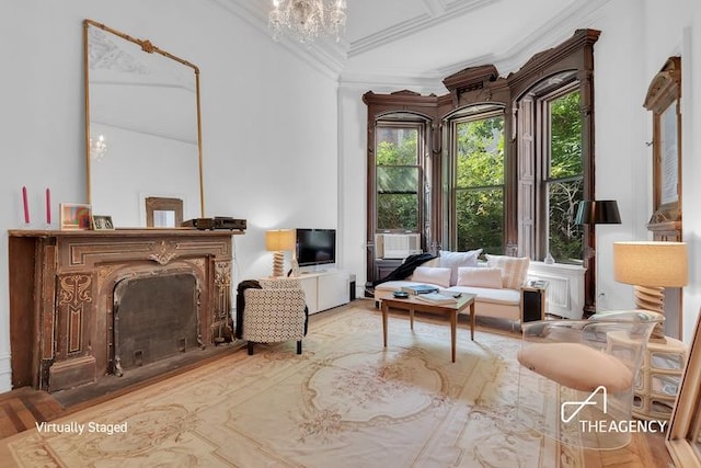 sitting room featuring an inviting chandelier, crown molding, and a high end fireplace