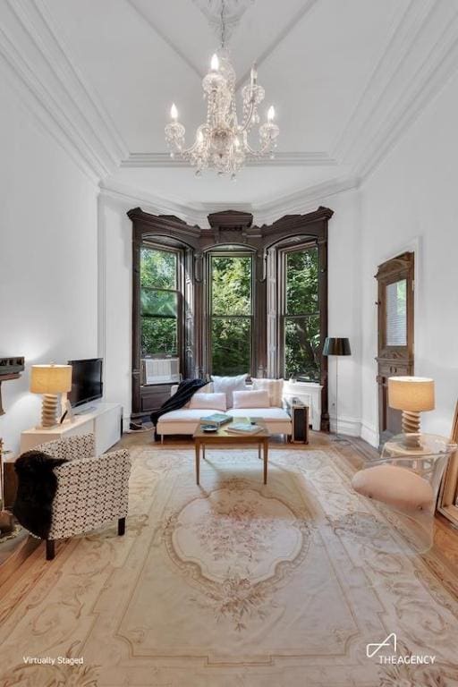 sitting room featuring an inviting chandelier, ornamental molding, and hardwood / wood-style floors