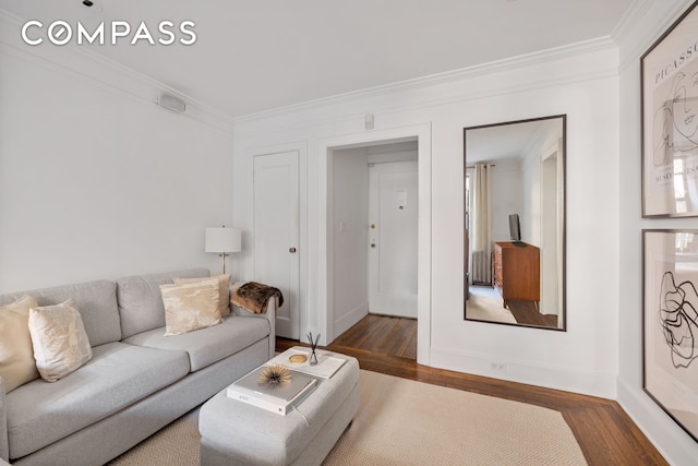 living room with wood finished floors, baseboards, and ornamental molding