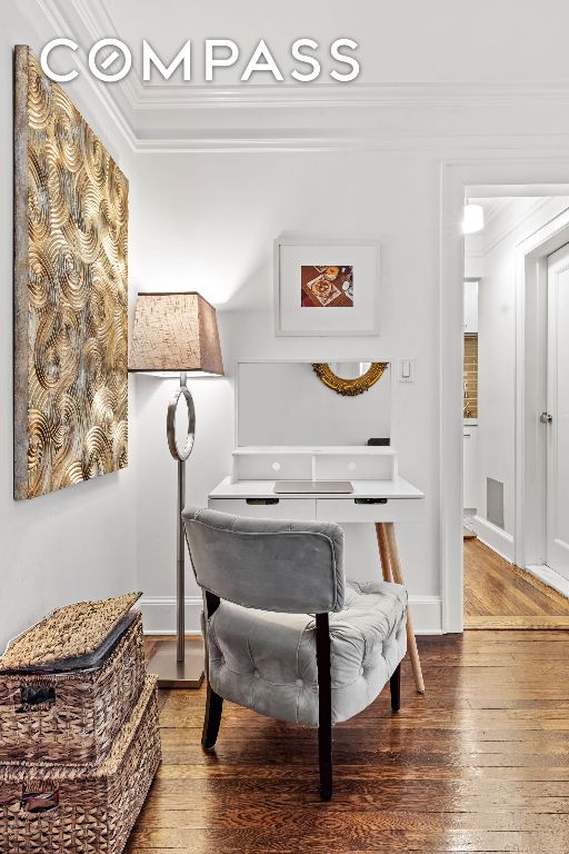 sitting room with ornamental molding and hardwood / wood-style floors