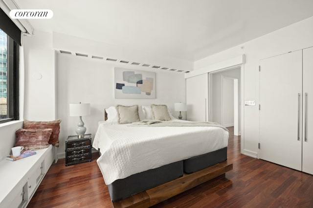 bedroom featuring dark hardwood / wood-style flooring and multiple closets