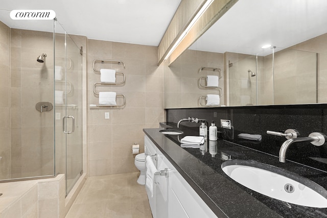 bathroom with tile walls, tile patterned flooring, a shower with door, and toilet