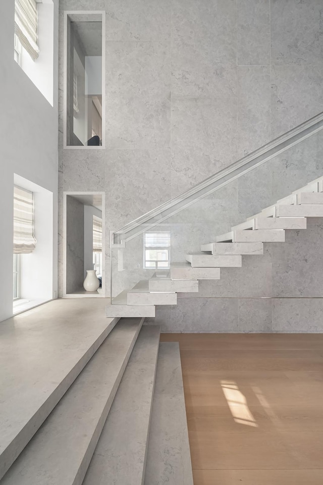 stairs with a high ceiling and wood finished floors