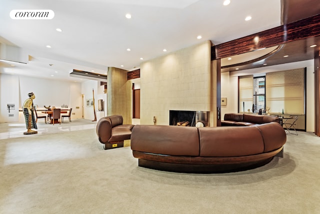 carpeted living room featuring a tile fireplace