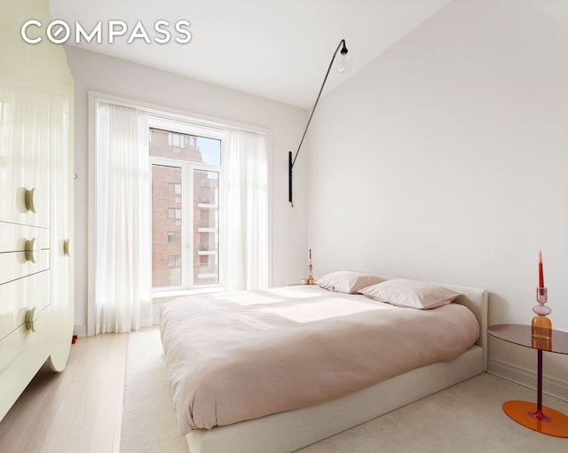 bedroom featuring lofted ceiling and wood finished floors