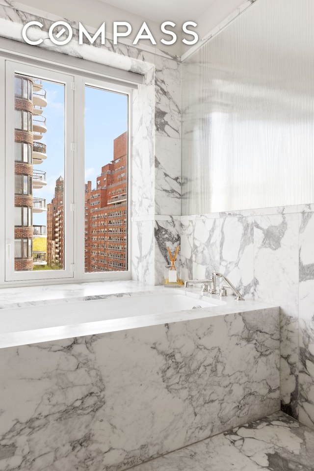 full bathroom with a garden tub and a view of city