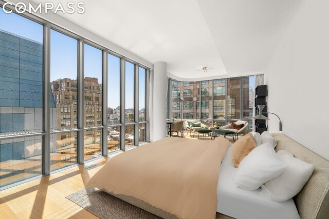 bedroom with a wall of windows and light wood-type flooring