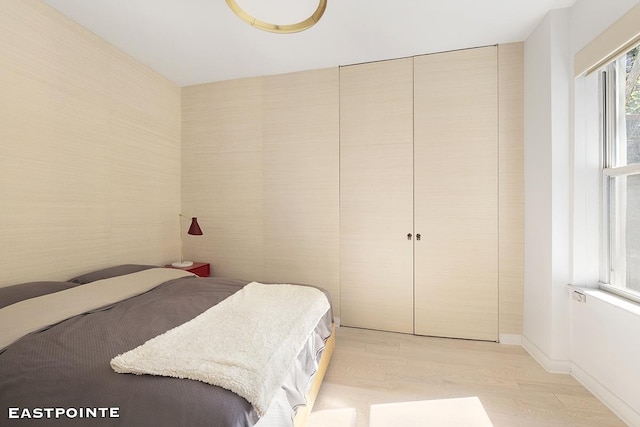 bedroom featuring light wood-style flooring and baseboards