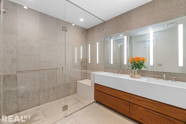 bathroom with an enclosed shower, vanity, and tile walls