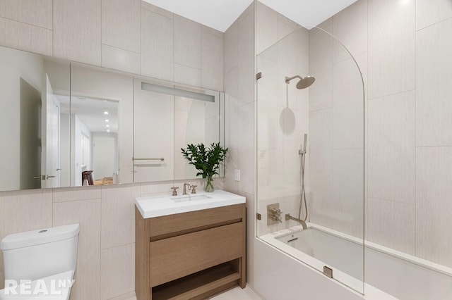 full bath featuring vanity, tile walls, toilet, and tub / shower combination