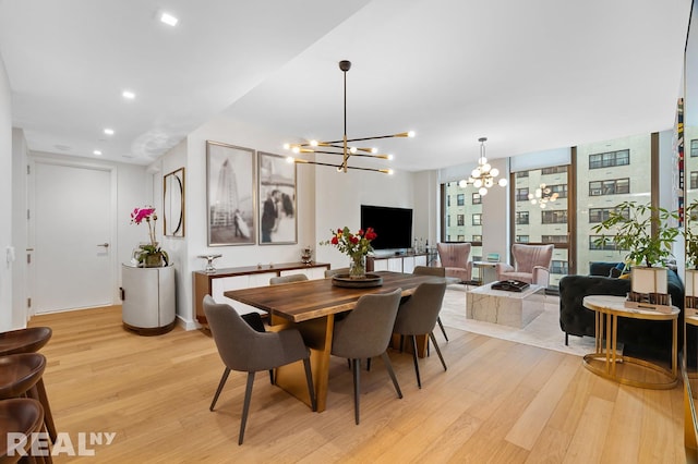 dining space with a notable chandelier, recessed lighting, and light wood-type flooring