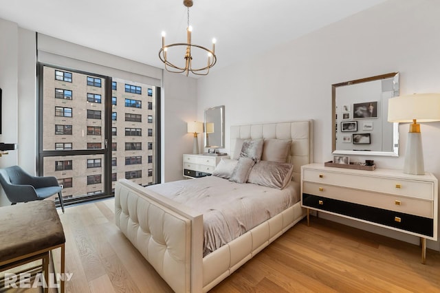 bedroom featuring light wood-type flooring and a notable chandelier