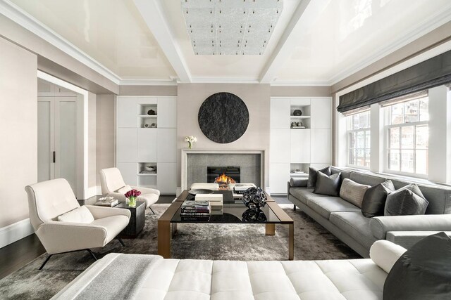 living room with beam ceiling, ornamental molding, dark hardwood / wood-style flooring, and built in shelves