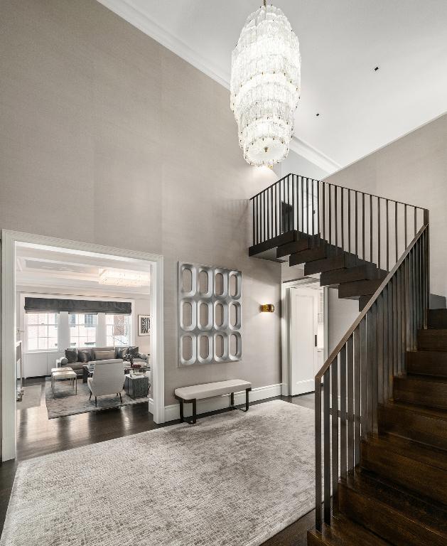 dining room with crown molding, a tray ceiling, dark hardwood / wood-style floors, and a notable chandelier