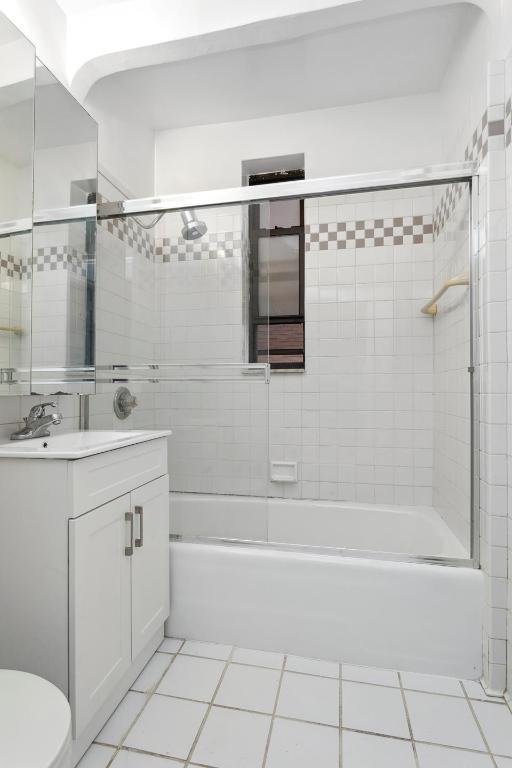 full bathroom featuring toilet, tile patterned flooring, tiled shower / bath combo, and vanity