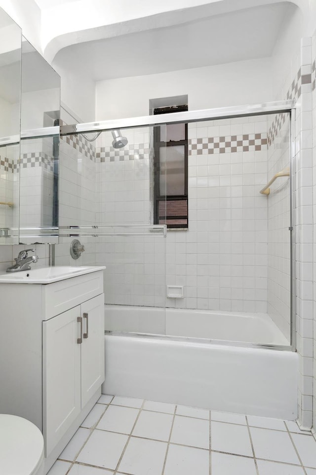 bathroom with shower / bath combination with glass door, vanity, toilet, and tile patterned floors