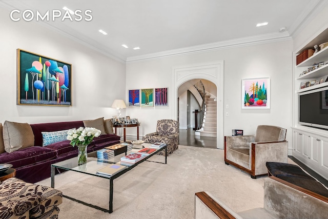 carpeted living area featuring stairs, ornamental molding, and arched walkways