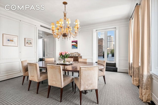 435 E 52nd St Unit 16C2, New York City, NY 10022 - dining space featuring a decorative wall, carpet flooring, a chandelier, and ornamental molding