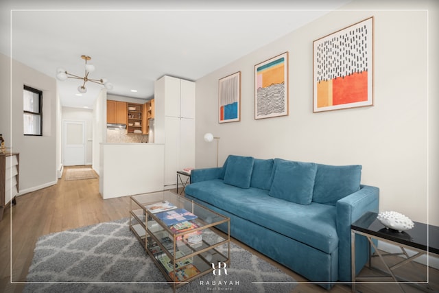 living room with light wood-type flooring and a chandelier