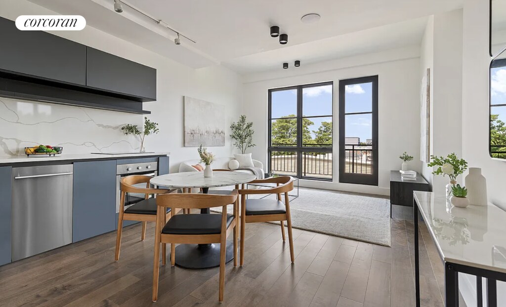 dining area featuring dark wood-type flooring and track lighting